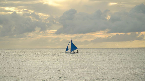 Sailing ship yachts with blue sails in the ocean at the sunset. sailing boat on sea. 