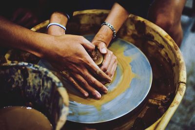 Midsection of people doing pottery