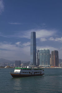 Sea by modern buildings against sky in city