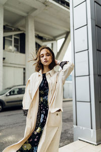 Portrait of woman standing against wall