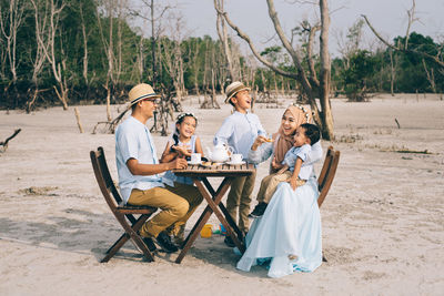 Family having breakfast while sitting on field