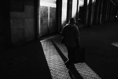 Rear view of man walking on sidewalk