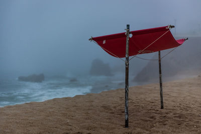 Lifeguard hut on beach against sky