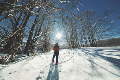 Full length of person on snow covered field against sky