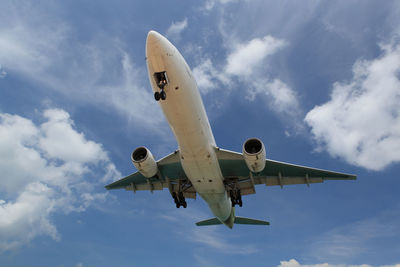 Low angle view of airplane flying against sky