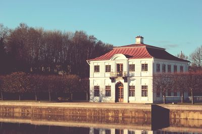 Building by lake against sky