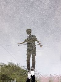 Reflection of man walking on puddle