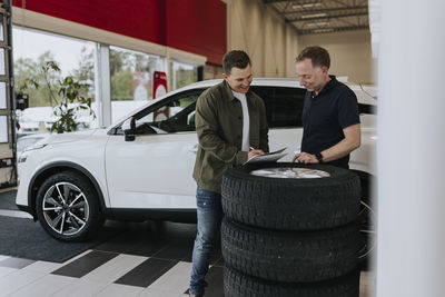 Man signing contract in car dealership