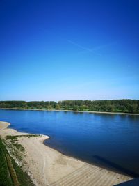 Scenic view of lake against clear blue sky