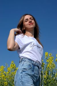 Portrait of young woman against blue sky