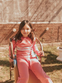 Portrait of young woman sitting on swing