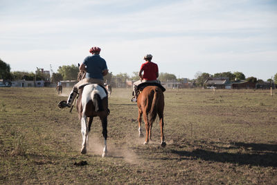 Argentinian father and son riding horse