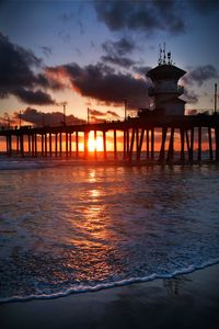 Pier over sea against sky during sunset