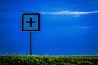 View of grassy field against blue sky