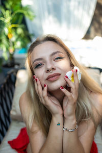 Portrait of young woman sitting on sofa at home
