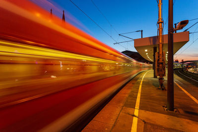 Blurred motion of train at railroad station against sky