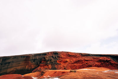 Rock formations on landscape against cloudy sky