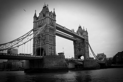 Low angle view of tower bridge over river against sky