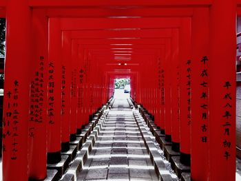 Footpath amidst red columns at shrine