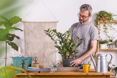Man standing by potted plant on table at home
