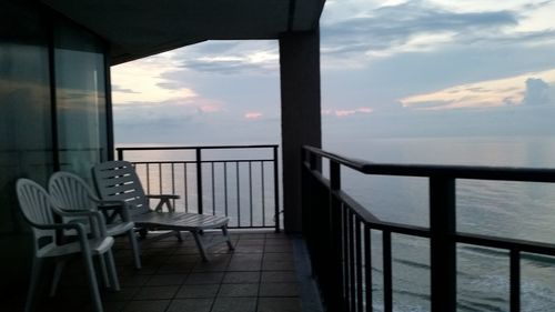 Empty chairs in front of sea