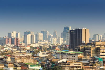 Buildings in city against clear sky