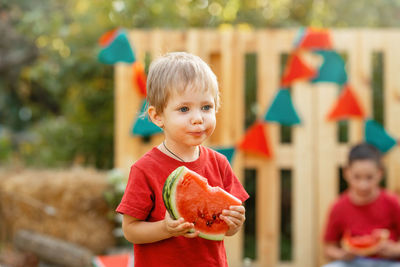 Portrait of cute boy holding watermelon