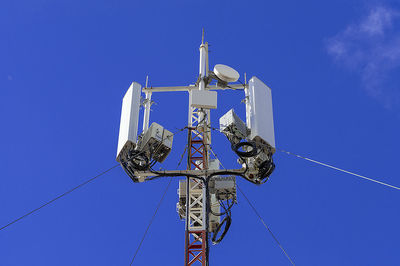 Low angle view of telephone pole against blue sky