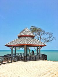 People are in pavilions on the mountains, below are beaches and the sea.