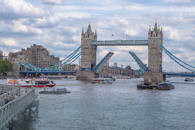 View of london bridge lifting for boats against cloudy sky