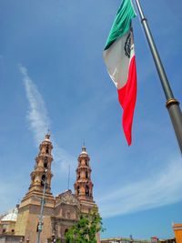 Low angle view of flag on building against sky