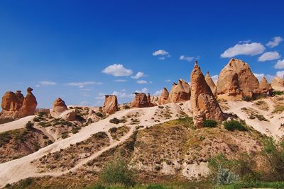 Rock formations on landscape against blue sky