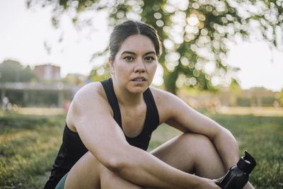 Portrait of exhausted woman sitting at park