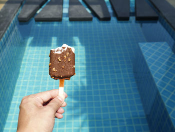 The left hand is holding chocolate ice cream that has already been eaten.