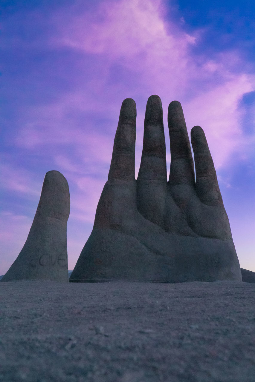 LOW ANGLE VIEW OF HAND SCULPTURE AGAINST SKY