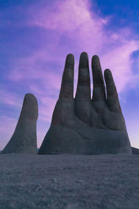 Low angle view of man sculpture against sky during sunset