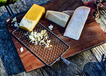 Still life with cheeses and cheese grater on wood cutting boards