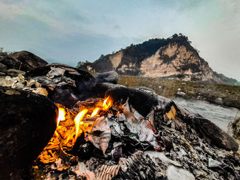 Bonfire on rock against sky