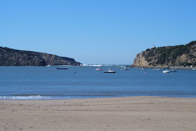 Boats in sea with mountain in background