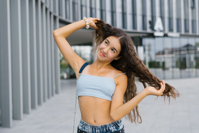 Young woman standing against building