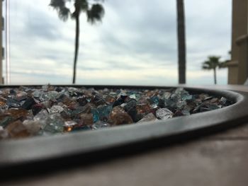 Close-up of stones on glass against sky