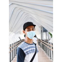Portrait of young man standing against building