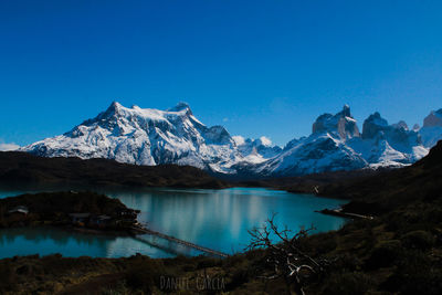 Scenic view of snowcapped mountains against clear blue sky