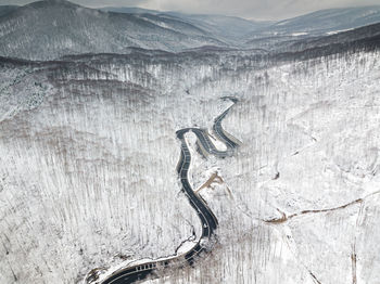 Aerial view of road on snow covered land during winter