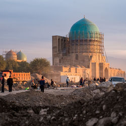 People at temple against sky in city