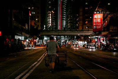 Rear view of man on railroad tracks at night