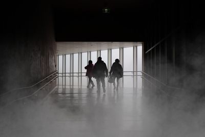 Silhouette people walking in corridor