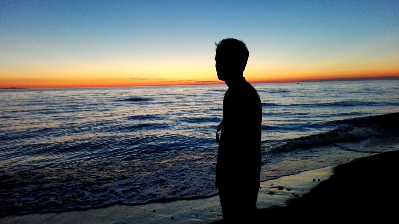 SILHOUETTE OF PEOPLE STANDING ON BEACH