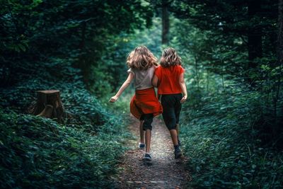 Rear view of women walking in forest