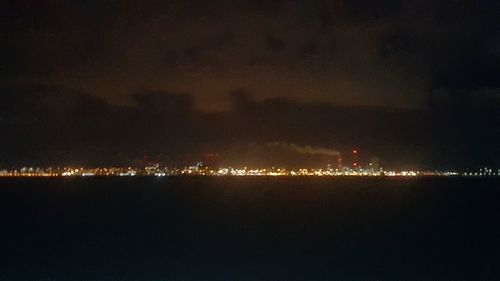 Illuminated cityscape against sky at night